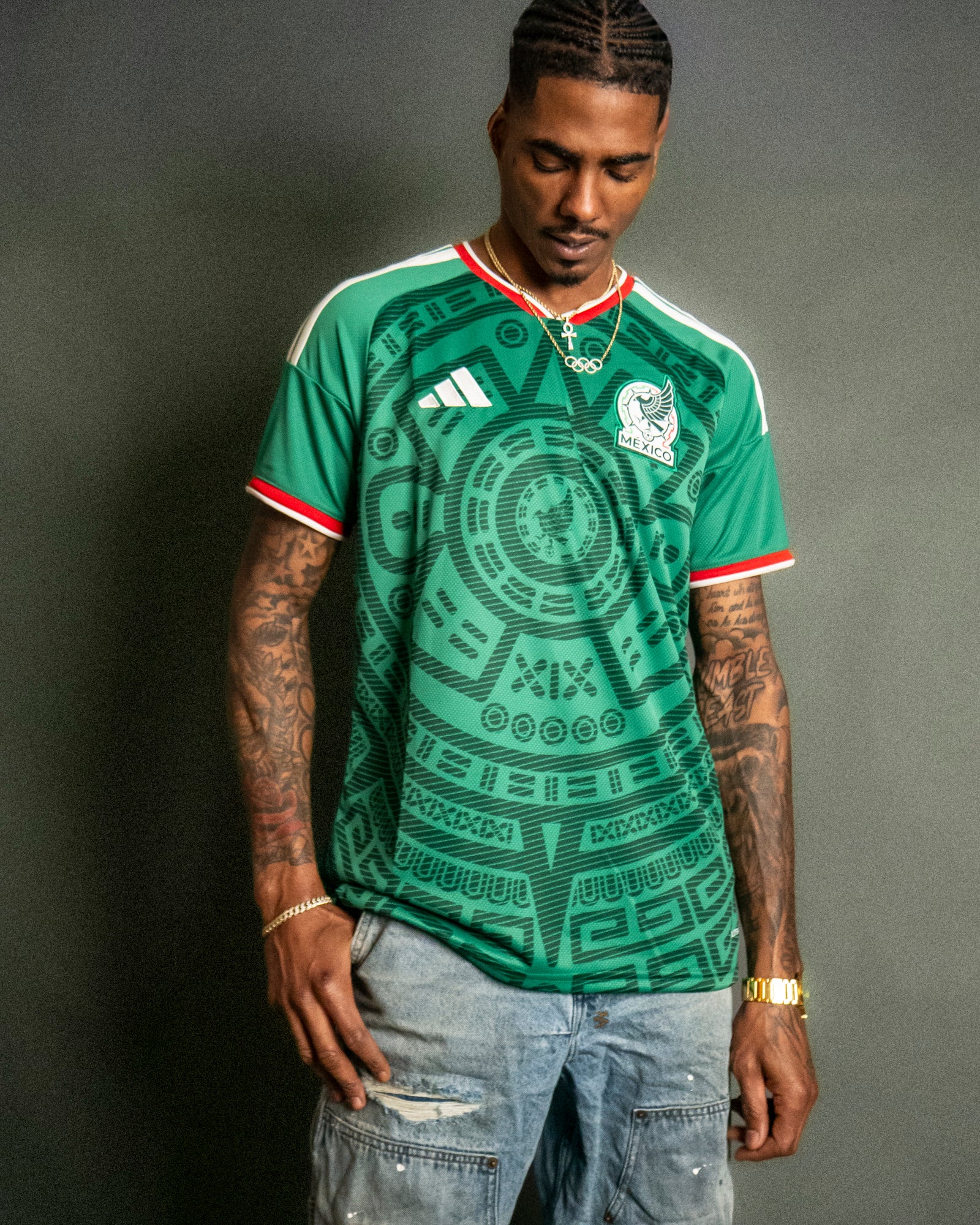 Man wearing a green sports jersey with Adidas logo on a gray background